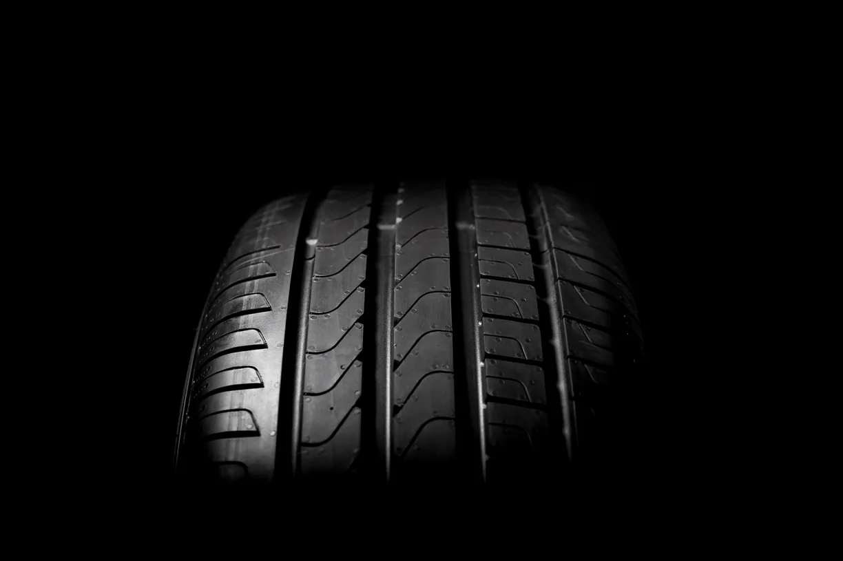 Close-up of a car tyre against a dark background.