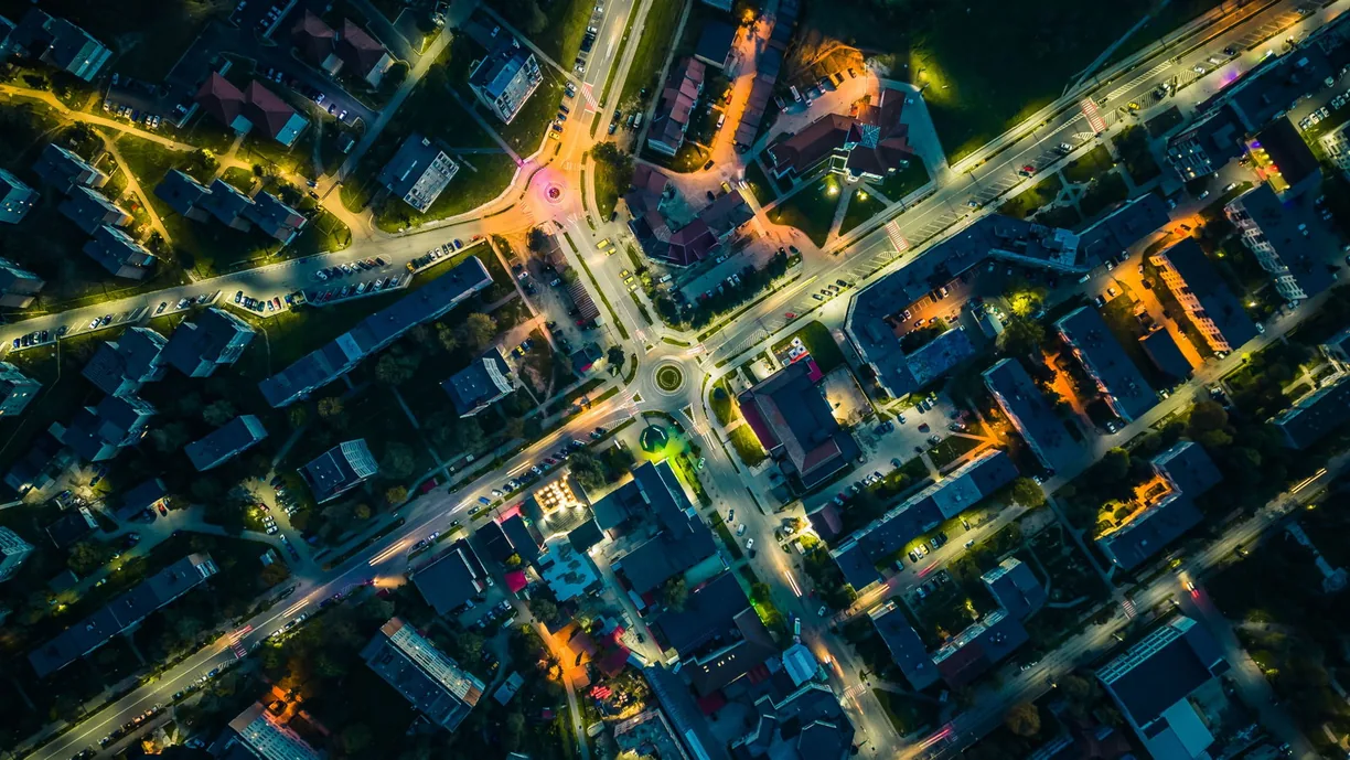 Aerial night view of a lit residential neighbourhood.