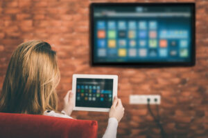 Una donna tiene un iPad davanti a sé e lo usa per trasmettere Chromecast sulla TV